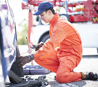 道路救援服务人员拆卸更换轮胎图片