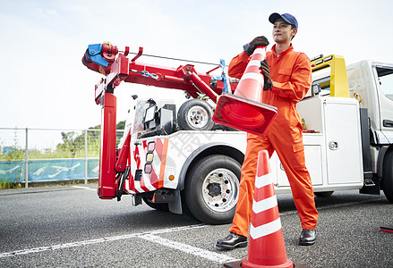 搬运放置路障锥桶的道路救援服务人员背景图片