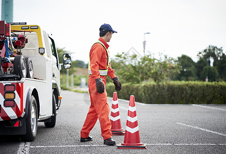 放置路障锥桶的道路救援服务人员背景图片