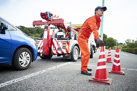 放置路障锥桶的道路救援服务人员背景图片