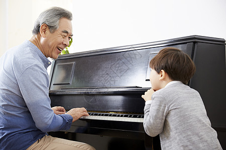 男孩看着祖父弹钢琴图片