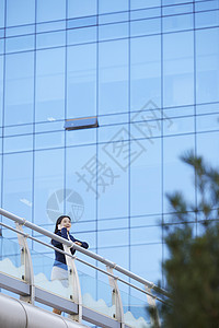 靠在栏杆上打电话的女青年图片