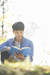 户外看书阅读的男青年图片
