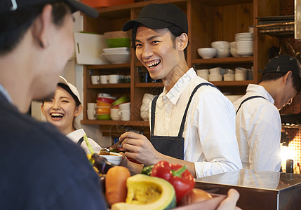 湖边餐厅在咖啡店厨房认真工作的年轻男女背景