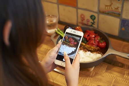 20多岁盆子餐具采取在智能手机的妇女一位厨师图片