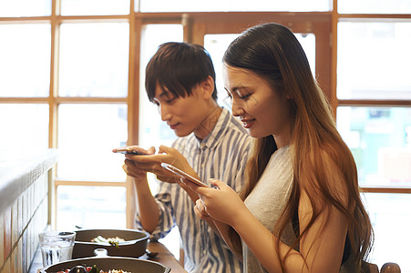 菜品痴迷年轻人采取与智能手机的夫妇食物图片