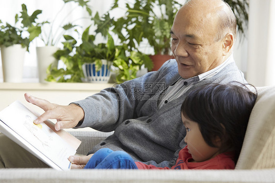 微笑的爷爷和孙子一起看书图片