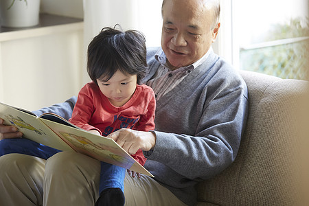 幼儿园纪念画册微笑的爷爷和孙子一起看书背景