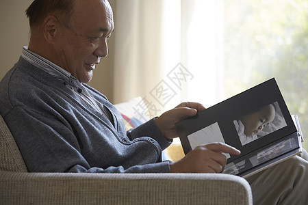 老人看着孙子的一家人相册照片图片