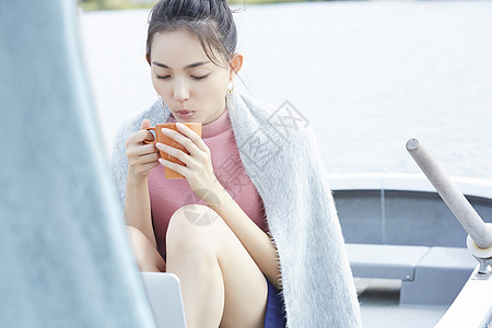 湖泊船上独自旅行的女人喝咖啡图片