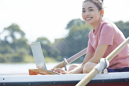 湖泊船上的年轻女孩用笔记本电脑图片