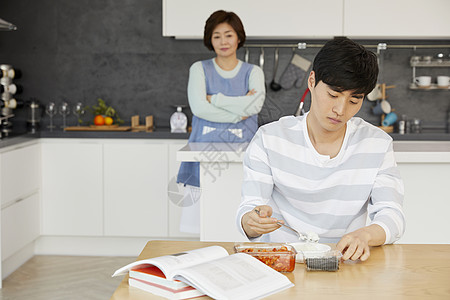 餐桌上吃饭冷漠的男青年图片