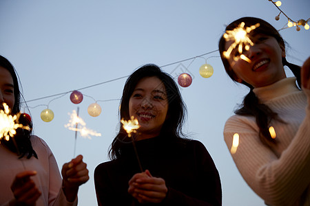 年轻女子在户外聚会放烟火图片