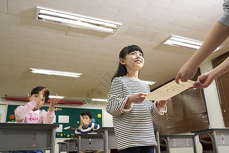 小学生接过老师给的奖励图片