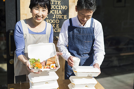 自由雇佣制笑脸家人卖午餐盒食物事务的已婚夫妇背景图片