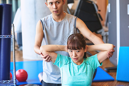 两个人女生户内行使在健身房的妇女和教练员背景图片