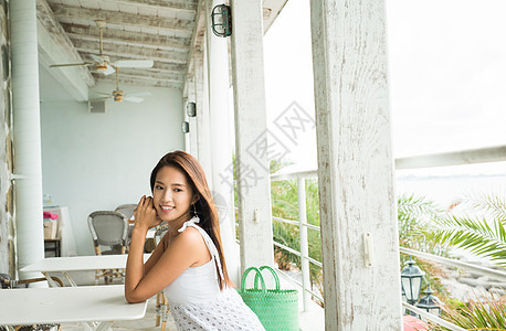 坐在咖啡厅里低头微笑的少女图片