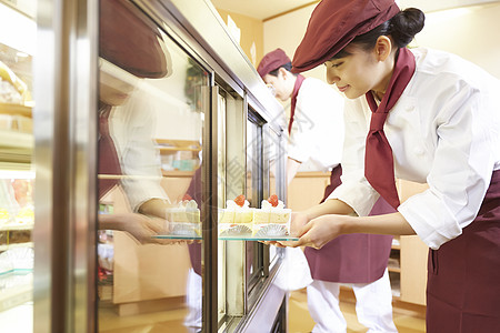 货物员工日本人做兼职工作的妇女在蛋糕商店图片