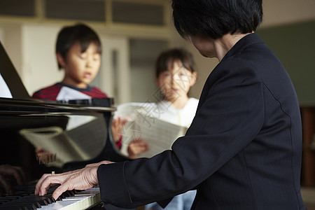 音乐室的老师教学生弹钢琴图片