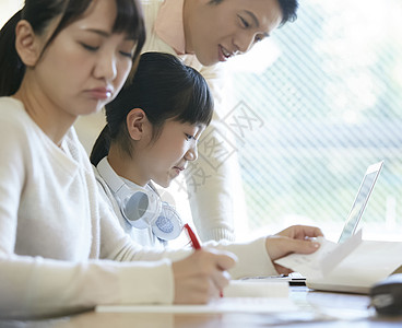 用笔记本电脑的女孩和父母一起学习图片