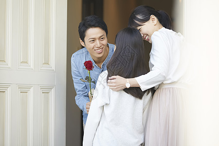 母女图片爸爸拿着一只花送给母亲和女儿背景