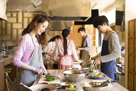 年轻男女烹饪课交流图片