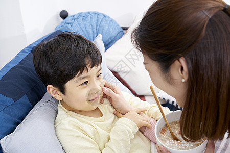 孩子趴在粥碗上妈妈照顾小男孩吃粥背景