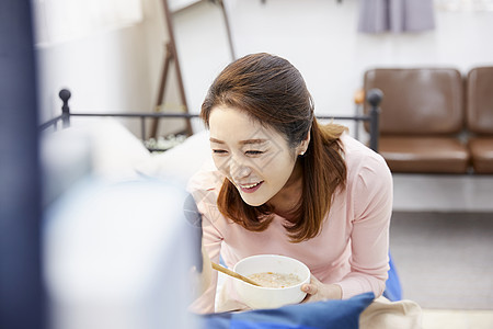 妈妈照顾生病在床的男孩吃粥背景图片