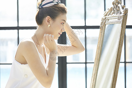 镜子前打扮微笑的女青年图片
