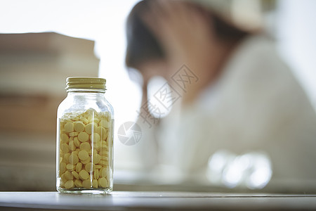 压抑女性镜头前的药瓶背景图片