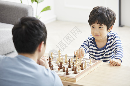 客厅里和父亲下象棋的小男孩图片