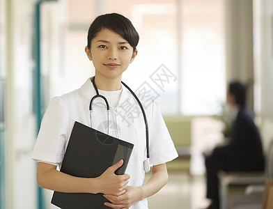 走廊里拿着医疗文件微笑的护士形象背景图片