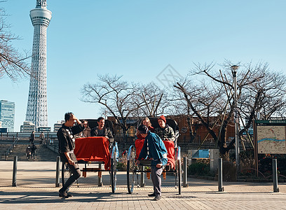 在东京旅游的外国游客乘坐人力车图片