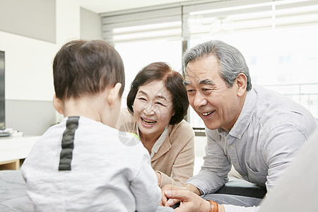 爷爷奶奶陪孙子在客厅玩游戏图片