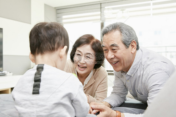 爷爷奶奶陪孙子在客厅玩游戏图片