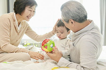 爷爷奶奶陪孙子在客厅玩游戏高清图片