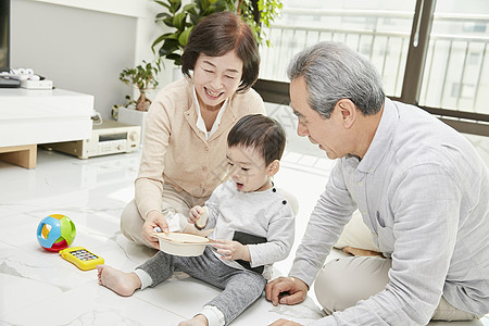 爷爷奶奶陪孙子在客厅玩耍图片