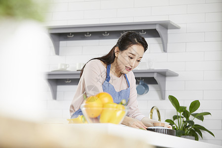 厨房里拿起锅子的成年女性图片