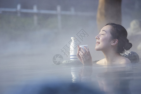 女人露天泡温泉喝清酒图片