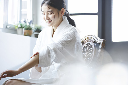 年轻女子使湿润乳霜女皮肤护理图片