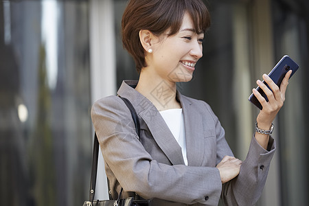 公司外面女商人用智能手机图片