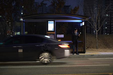 在公交车站等车的白领男子图片
