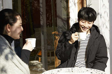 年轻男女屋外晒太阳聊天喝茶图片