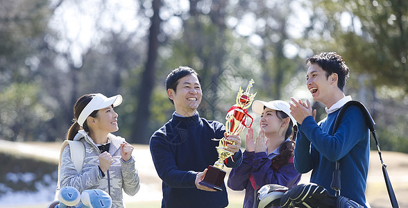在高尔夫球球场举起奖杯背景图片