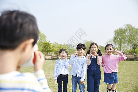 男孩在公园给朋友们拍照图片