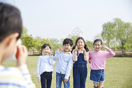 男孩在公园给朋友们拍照图片