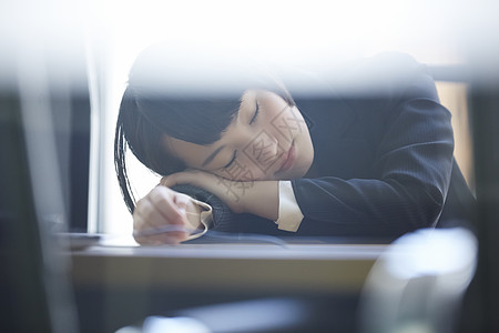 趴在桌上休息的商务女性图片