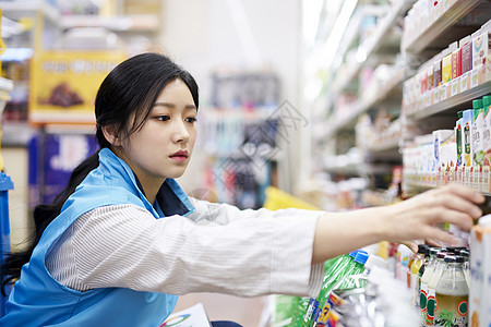 便利店整理商品的年轻女子图片