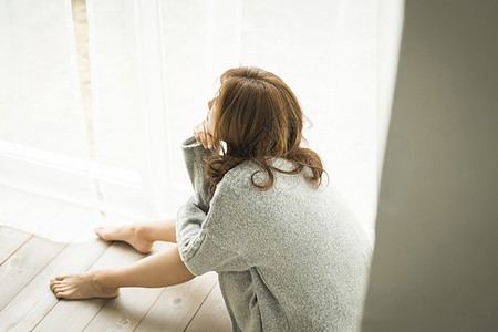 女孩独自在客厅静坐沉思图片