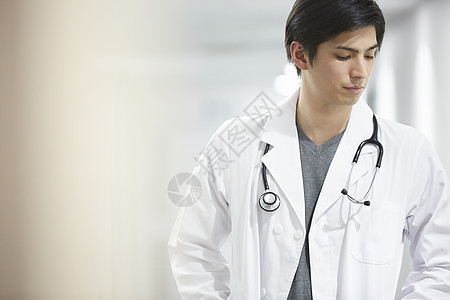 医院走廊的低头走路的男医生图片